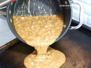 Almond roca being poured in pan to harden.