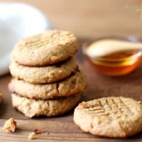 Paleo Peanut Butter Cookies are healthy cookies on a counter with honey in the background.