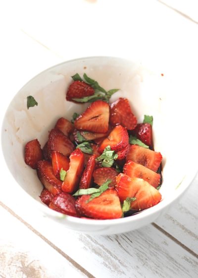 Fresh cut strawberries mixed with fresh basil. 