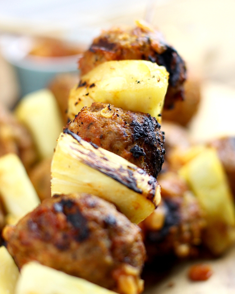 Close up image of Pineapple meatballs skewers with grill marks.