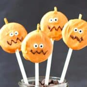 Oreo pumpkin pops on sticks in a jar.