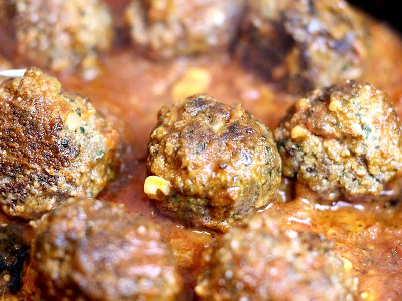 Italian Meatballs in a skillet with marinara sauce.