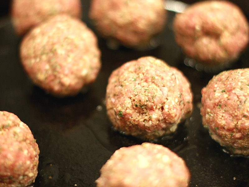 Meatball Parmesan Bites cooking in a skillet.