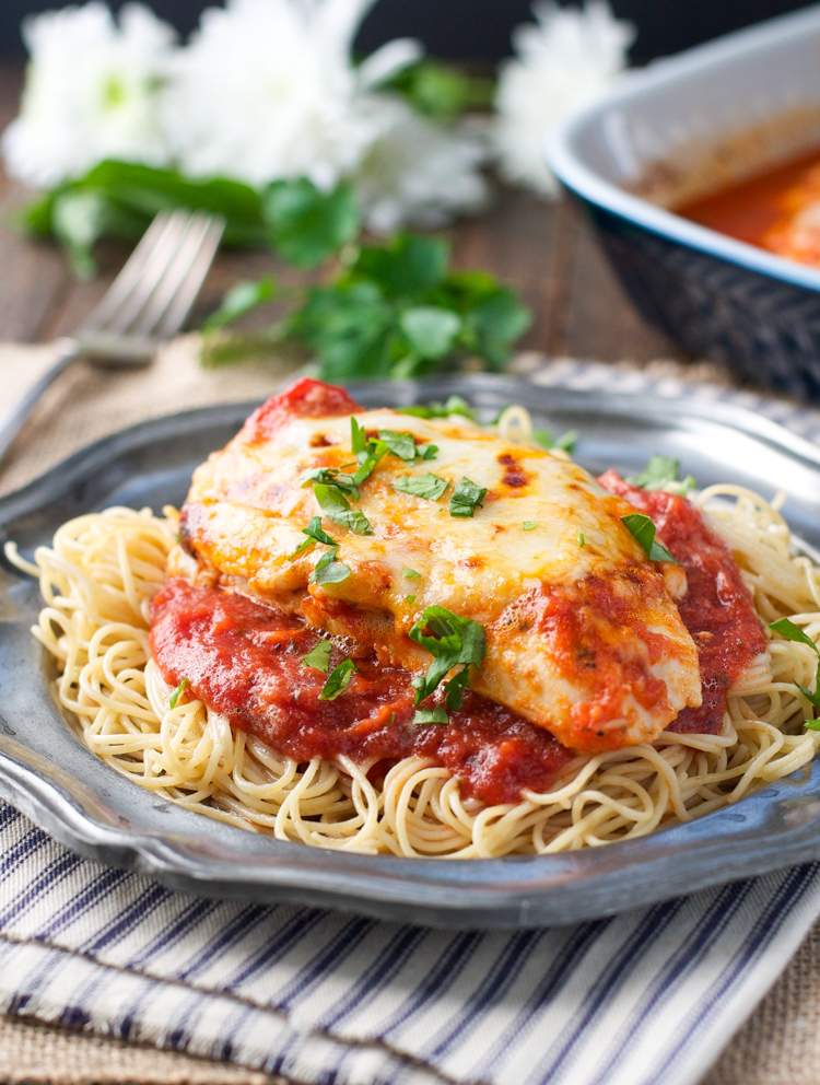 Baked chicken parmesan on a plate with a napkin underneath. 