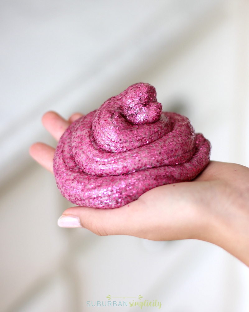 Pink glitter Slime curled into the palm of a hand.