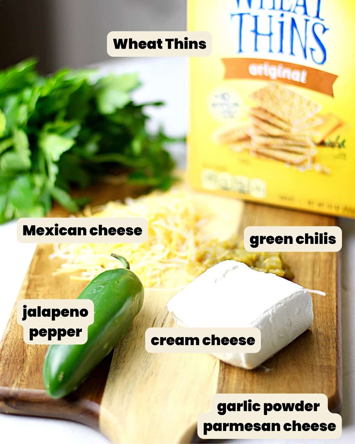 Ingredients on a cutting board to make crackers topped with jalapeno and cheese.