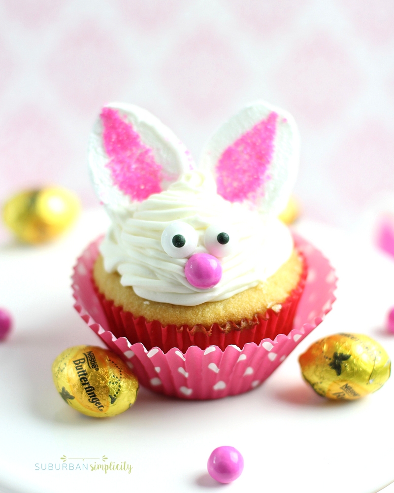 Bunny cupcake in a pink wrapper and Butterfinger candies next to it. 