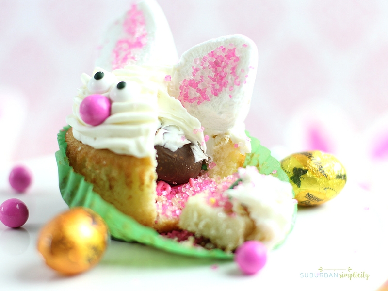 A bunny cupcake opened up to see the  candy surprise inside.