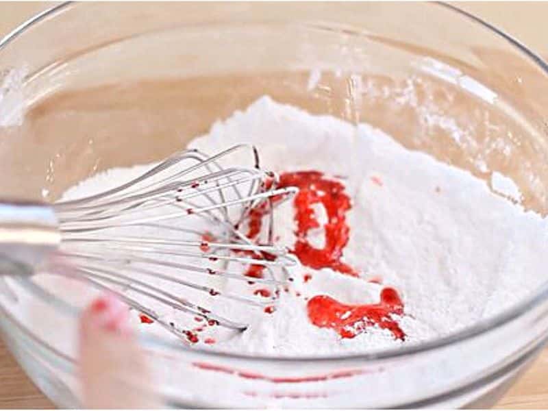 Bowl containing wet and dry ingredients to make a bath bomb.