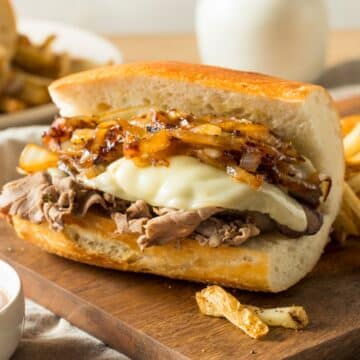 An open face frenchdip sandwich with onions.