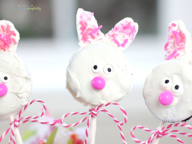 Three Easter Oreo Cookie Pops with a ribbon around their lollipop sticks.