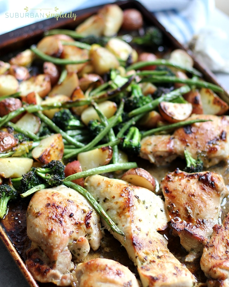 Delicious chicken and veggies roasted in the oven on a pan.