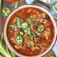 Healthy Crockpot Turkey Chili with jalapeño and green onion garnish