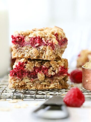 These Raspberry Oatmeal Bars are a must-try! You'll love the few simple ingredients that come together to make a delicious crust and crumble layered with fresh raspberries. With whole grains and minimal sugar, they're a healthier option for a grab-n-go breakfast or tasty snack!