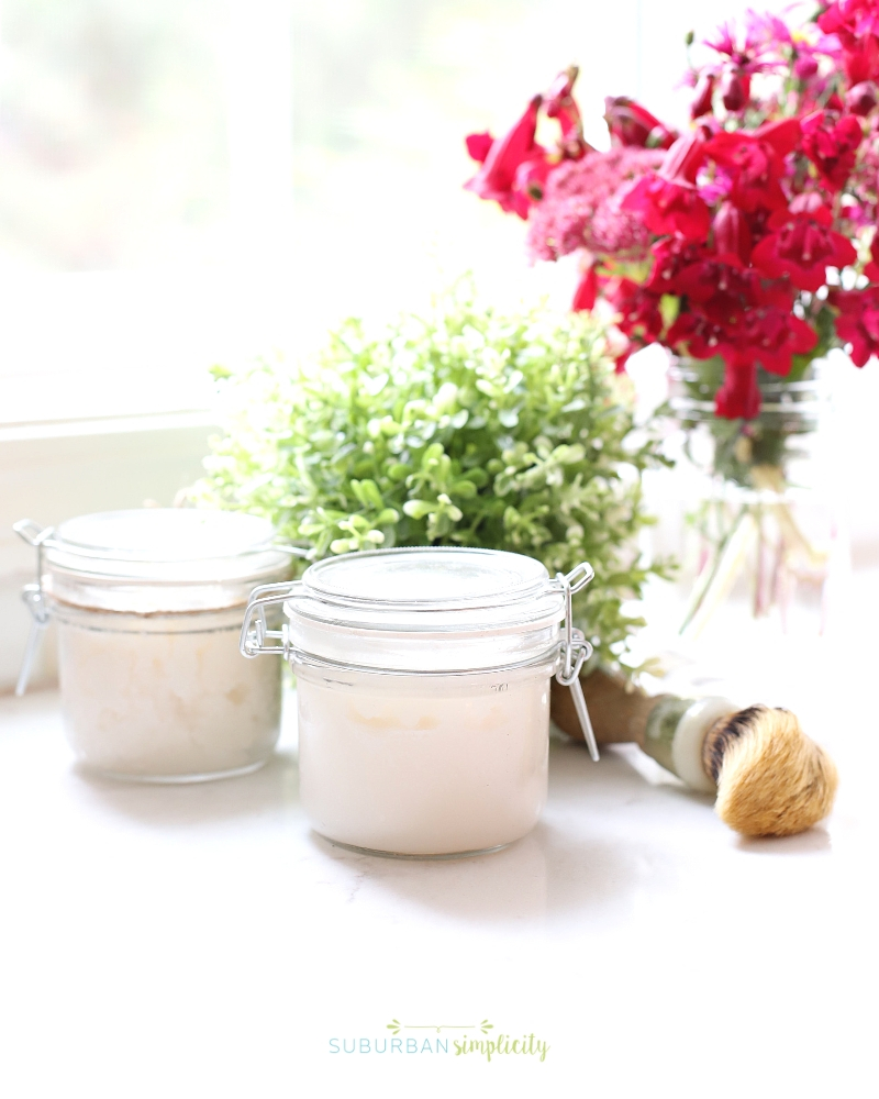 Jar of body scrub on the counter with flowers in the background.