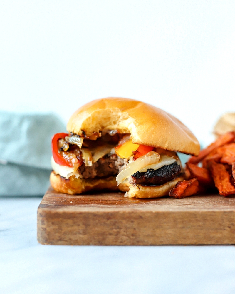 Burger on a cutting board with a bite out.