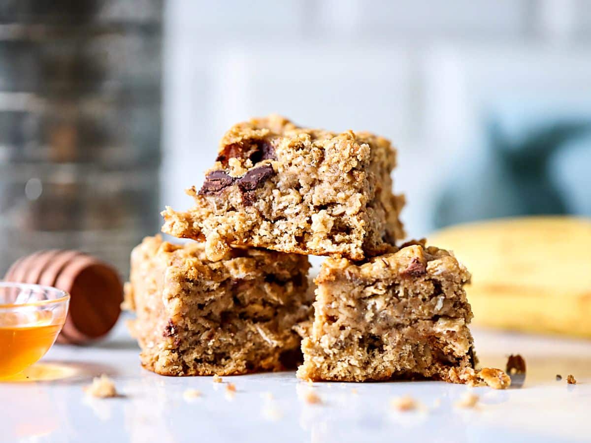 Three oatmeal bars with bananas stacked on each other.