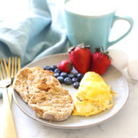 1-minute sausage and cheese omelet on a plate with fruit.