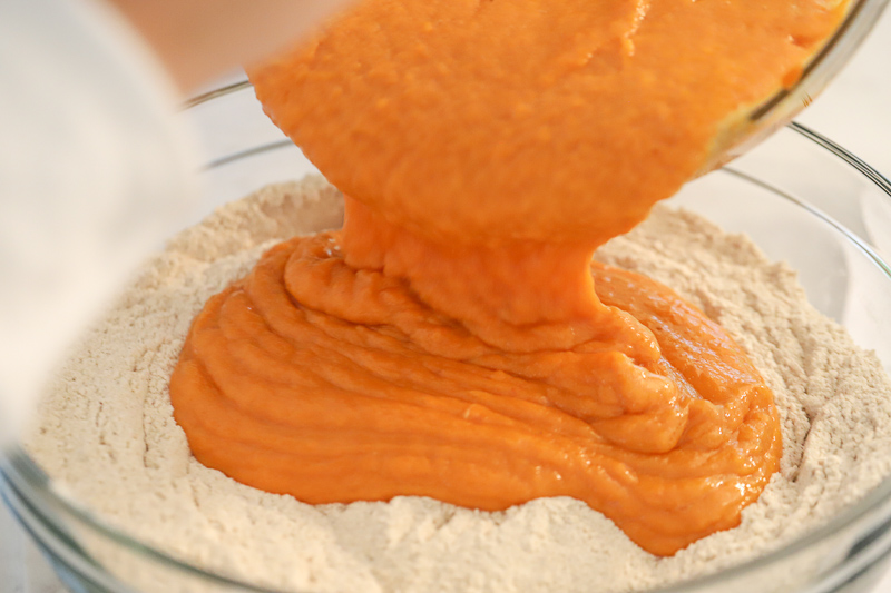 Ingredients being added to pumpkin muffin batter