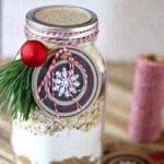 Christmas cookies in a jar with a tag and ornament.