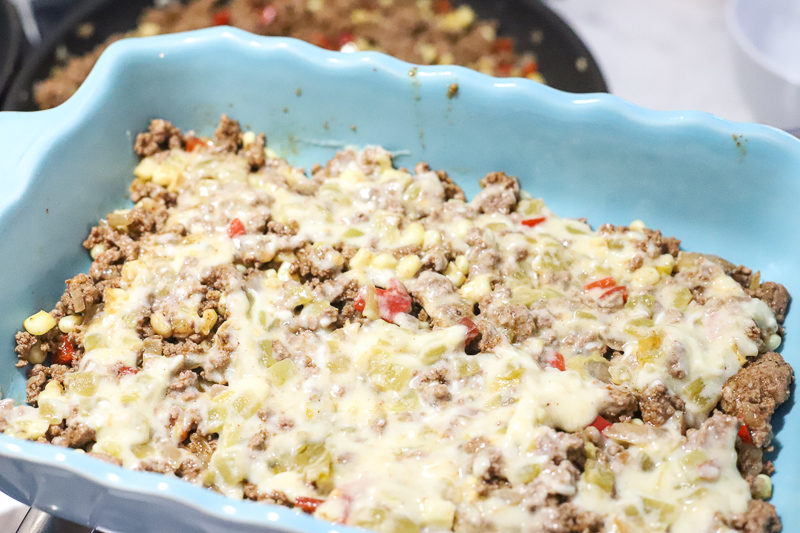 ingredients in a baking dish for beef enchilada casserole.