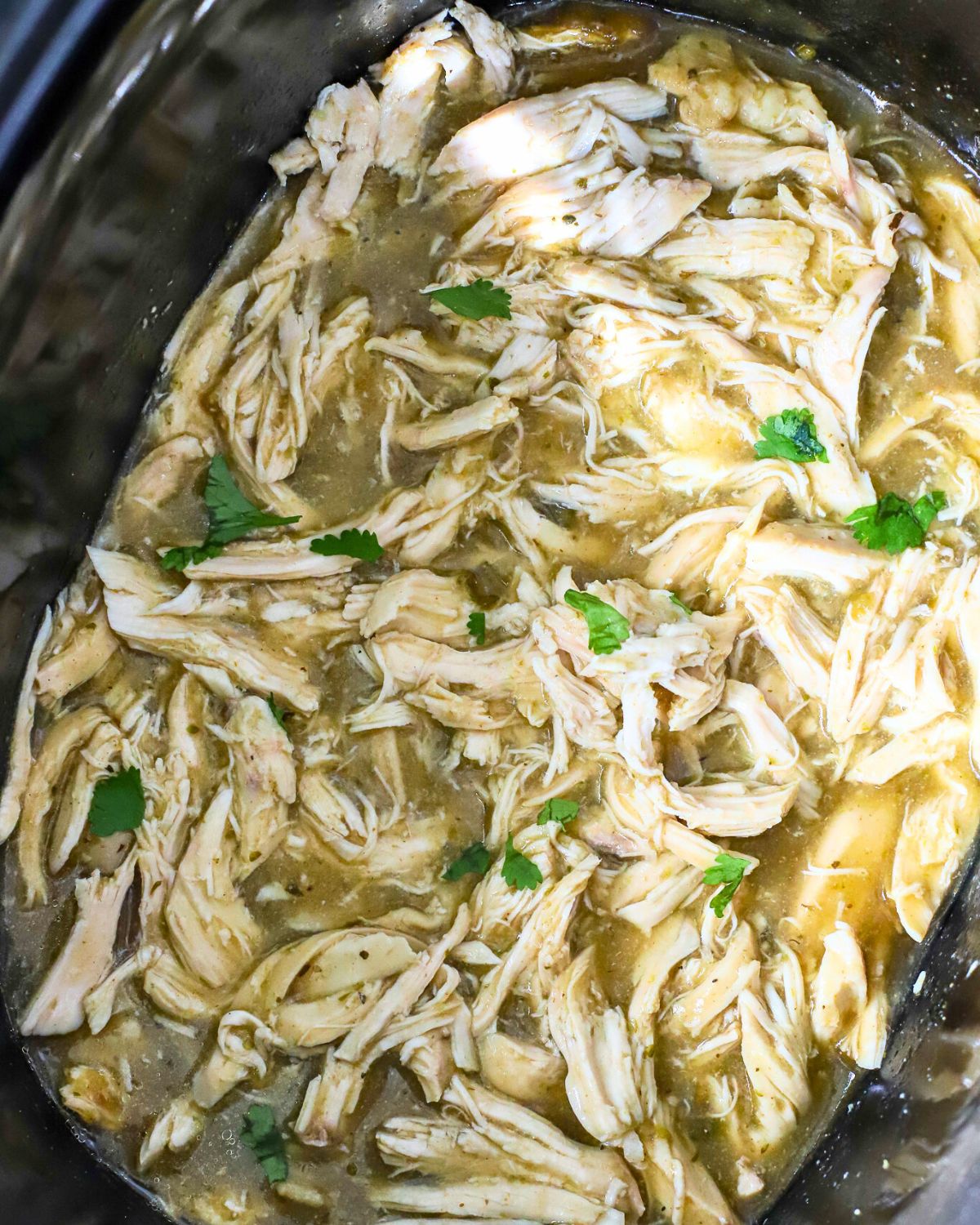 Shredded salsa verde chicken in the slow cooker.