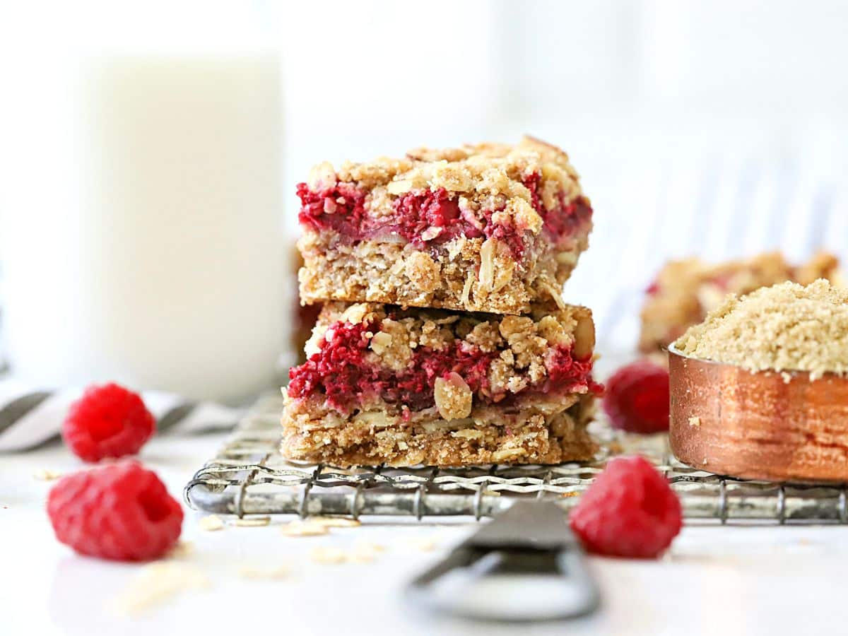 Oatmeal bars with raspberries stack on each other.