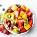 Fruit salad in a white bowl.