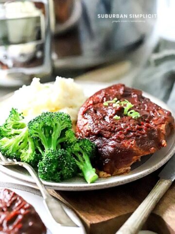 BBQ pork chops on a plate with broccoli and mashed potatoes