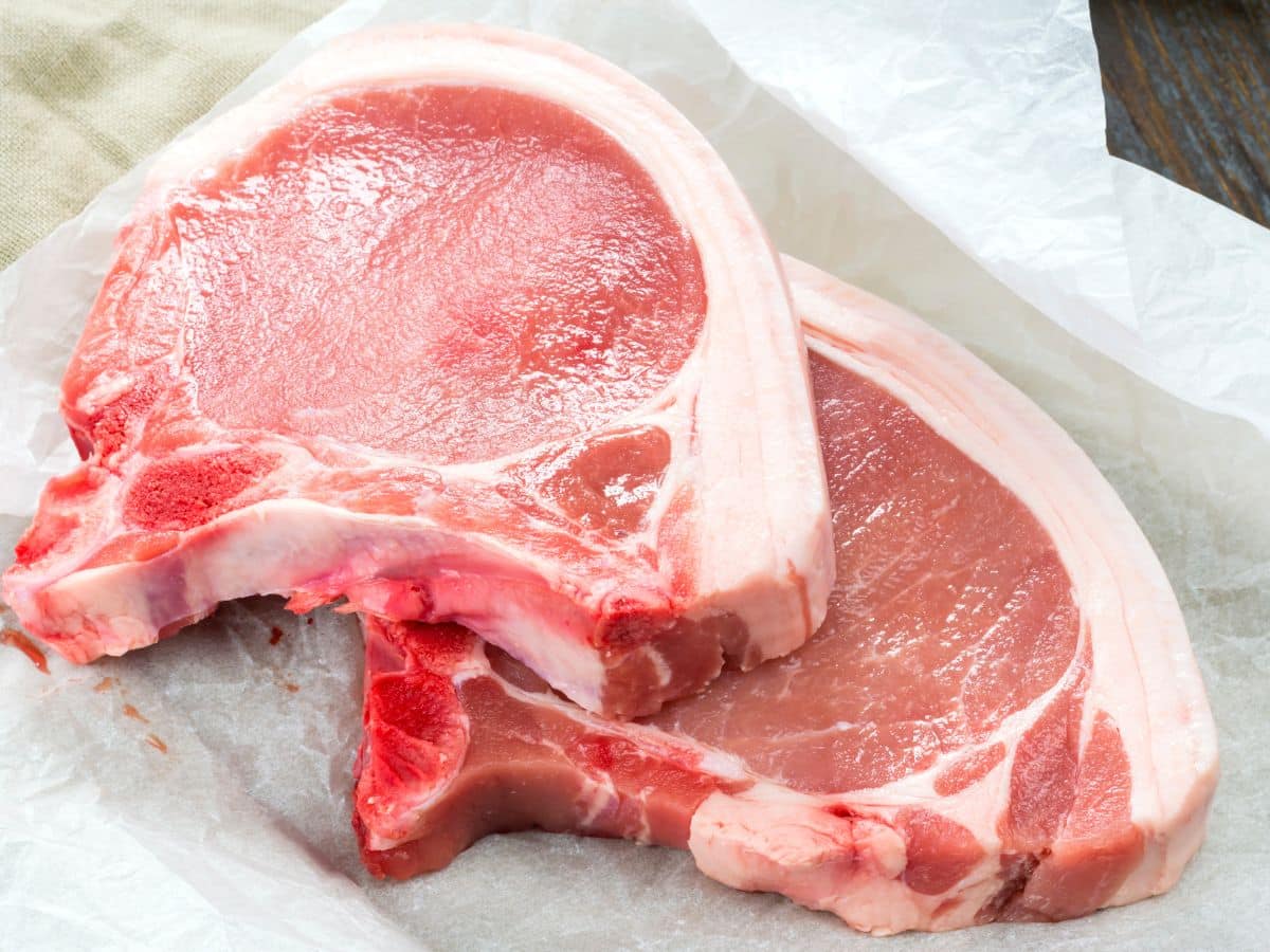 Raw bone-in pork chops.