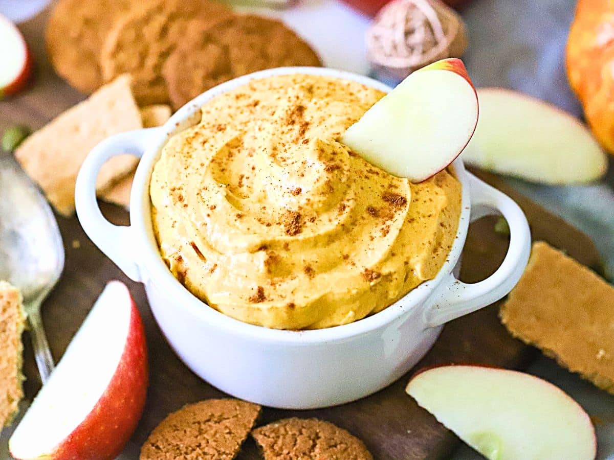 Small white bowl filled with a dip made pumpkin and cream cheese.