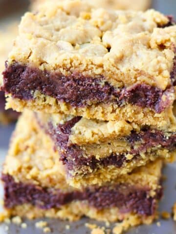 Three chocolate peanut butter bars stacked on top of each other.