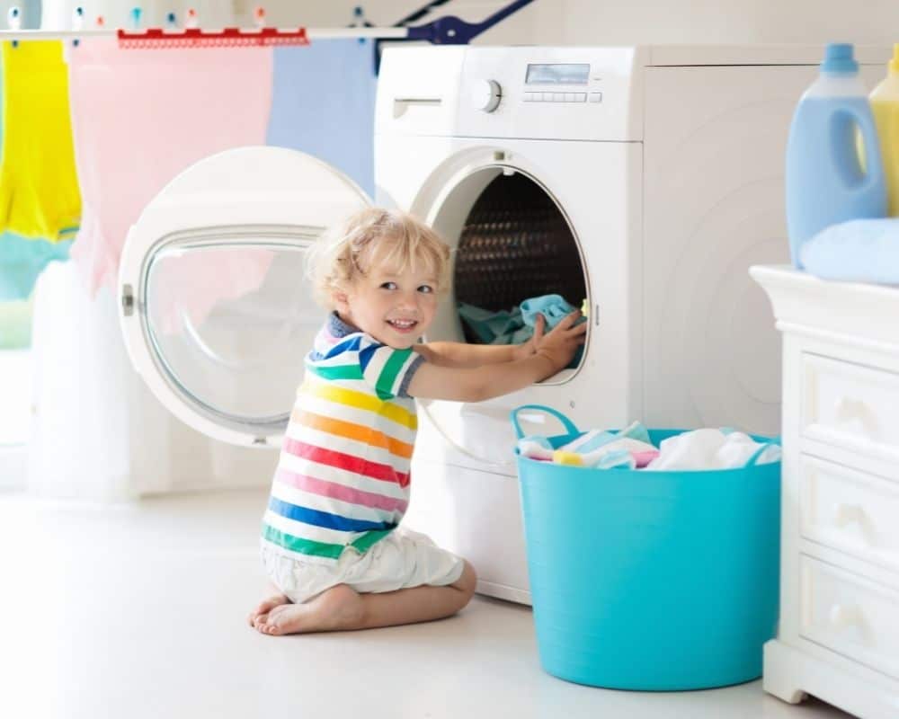 toddler in front of washing machine