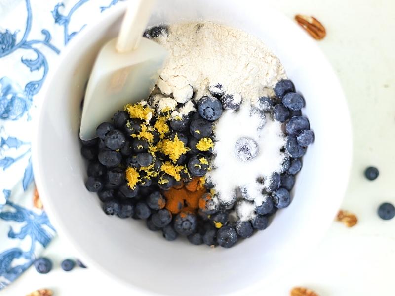 Blueberries with sugar, lemon, and flour in a bowl