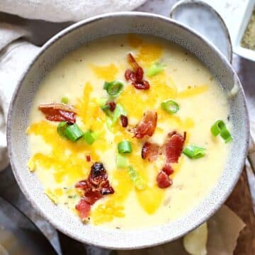 A bowl of Instant Pot Potato soup with bacon and green onion on top.