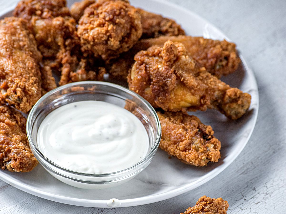 chicken fingers with ranch dipping sauce on a plate.