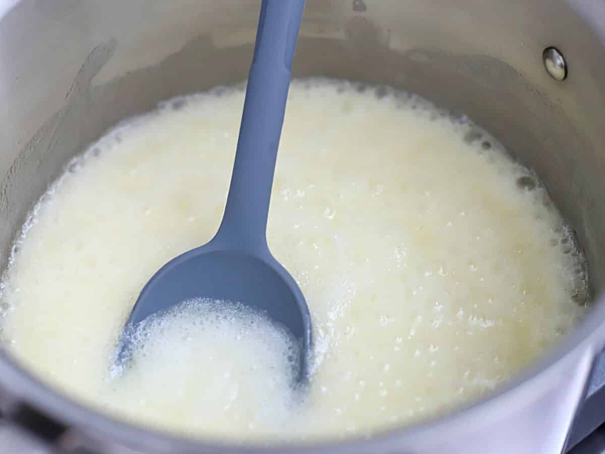 sugar, milk and butter boiling in a pot.