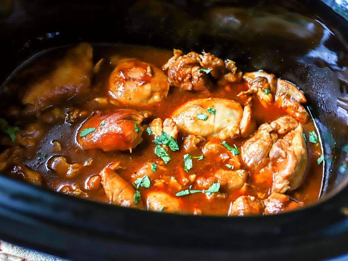 Chicken thighs cooked in a slow cooker with BBQ sauce.