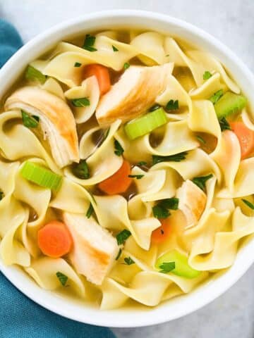 Chicken noodle soup in a white bowl.