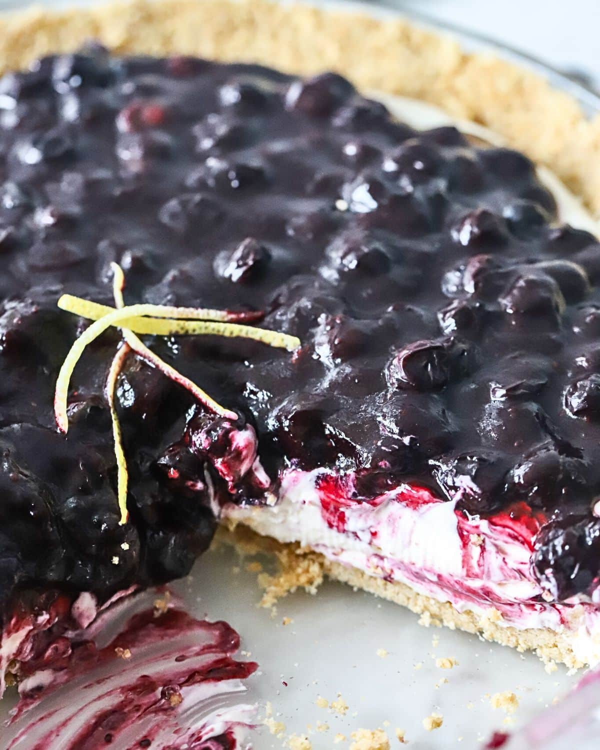 A blueberry cheesecake pie with a slice cut out.