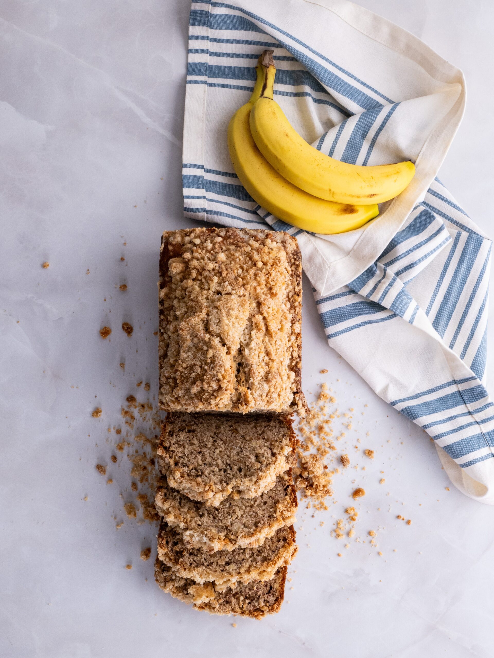 Banana bread topped with streusel cut into slices.