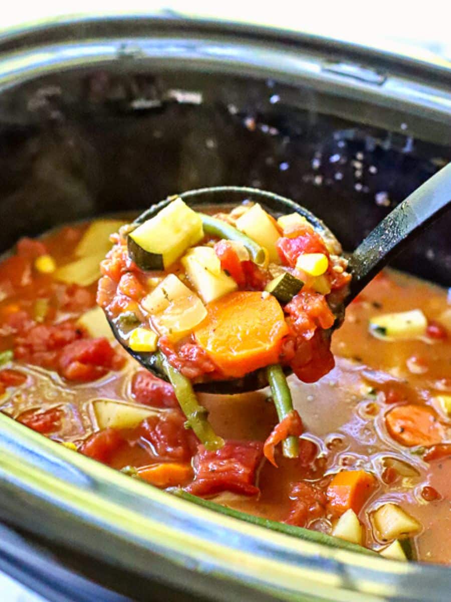 Crock Pot Vegetable soup being ladled out of the slow cooker.