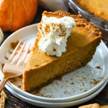 A slice of Pumpkin pie with whipped cream on top.