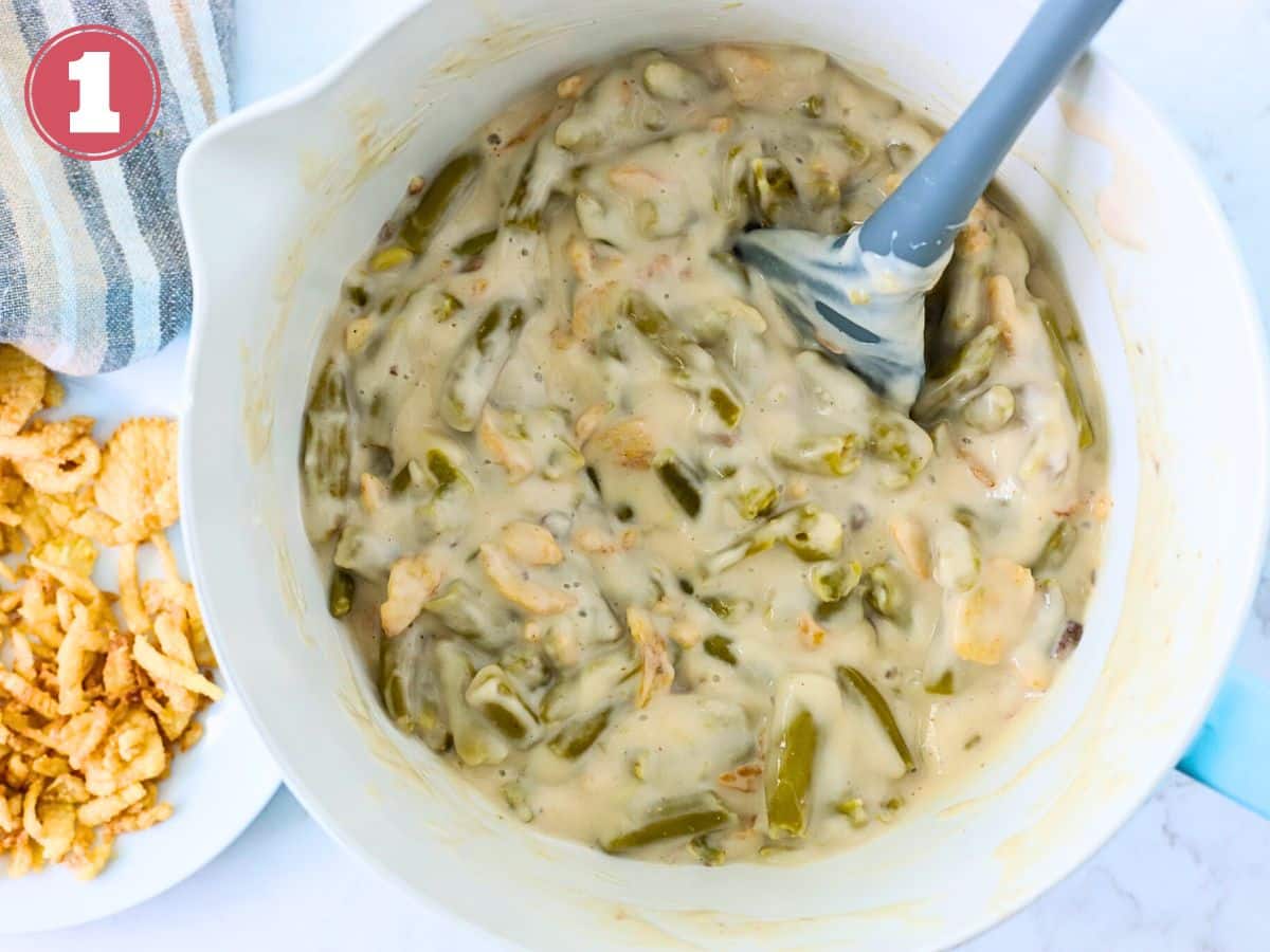 Cream of mushroom soup, green beans and fried onions in a bowl.