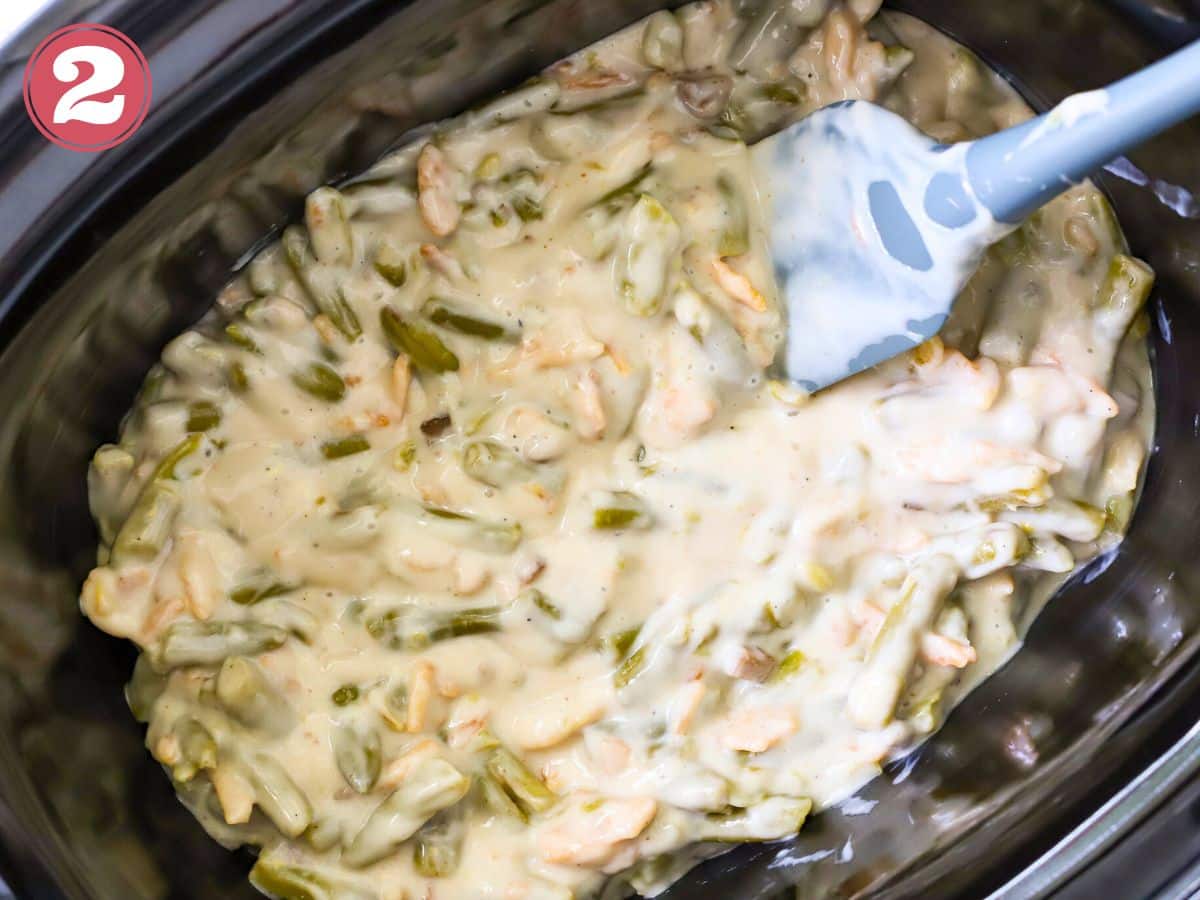 Green bean casserole in a crock pot ready to be cooked.