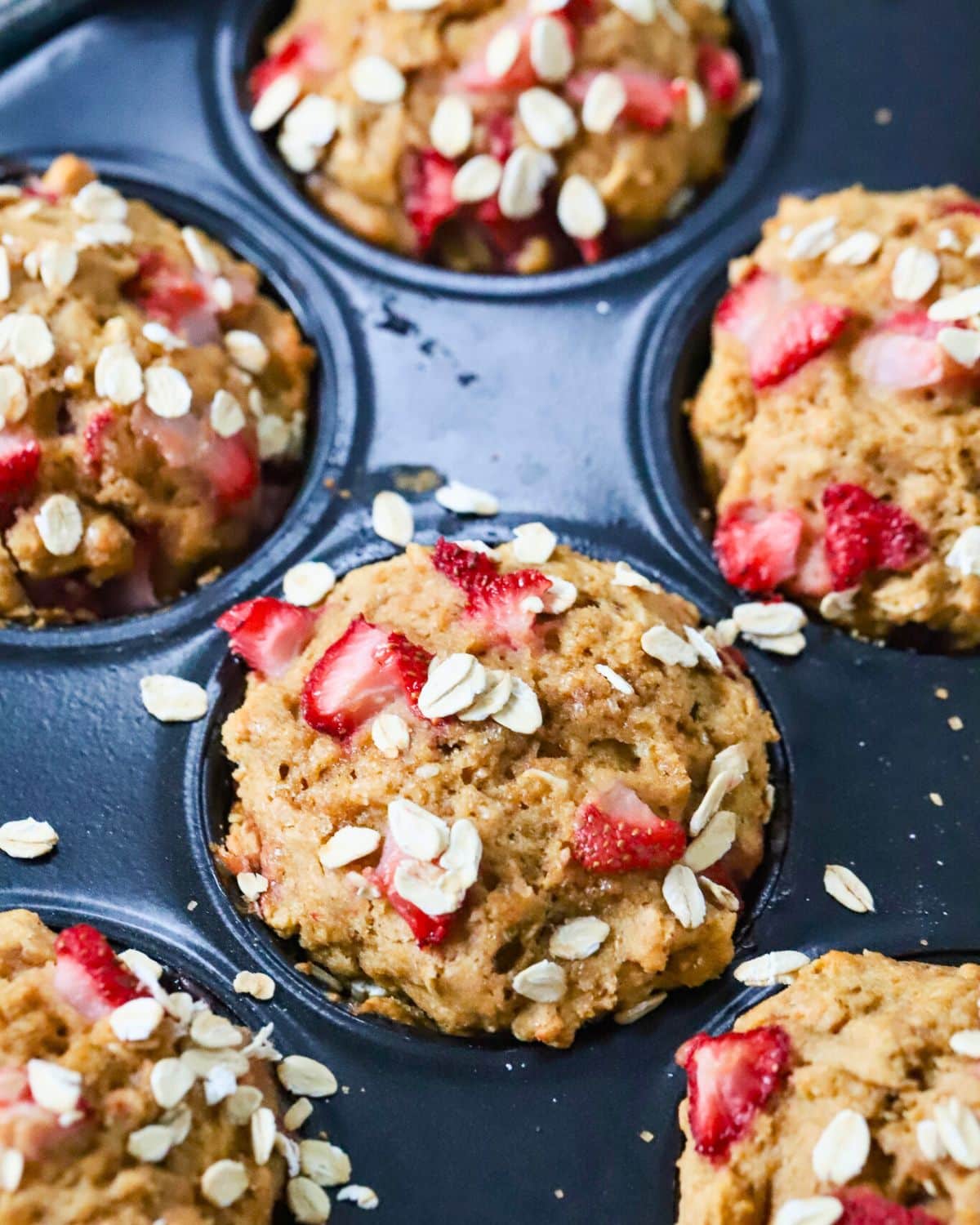 Close up of a strawberry muffins with strawberries on top.