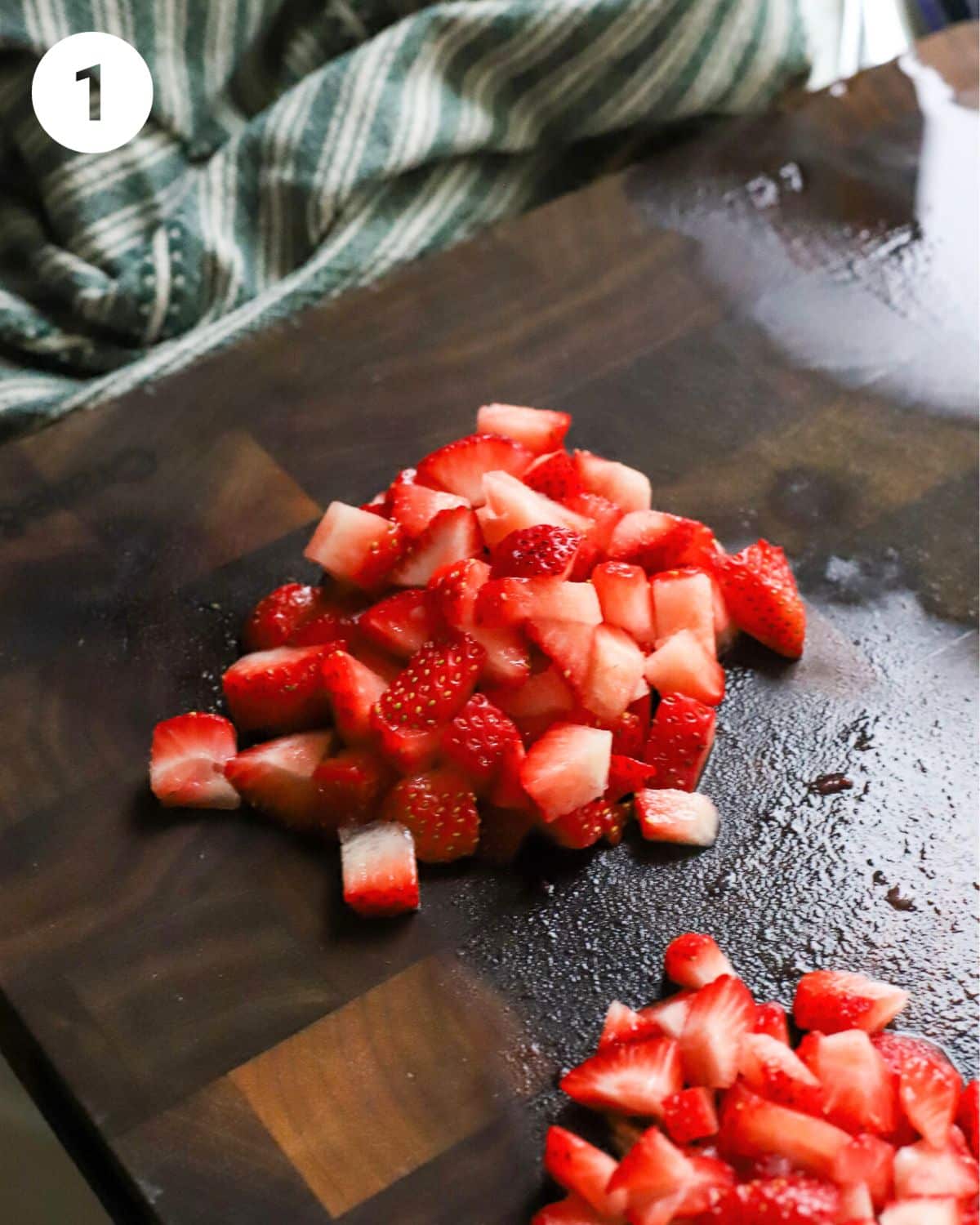 Fresh cut strawberries on a cutting board.