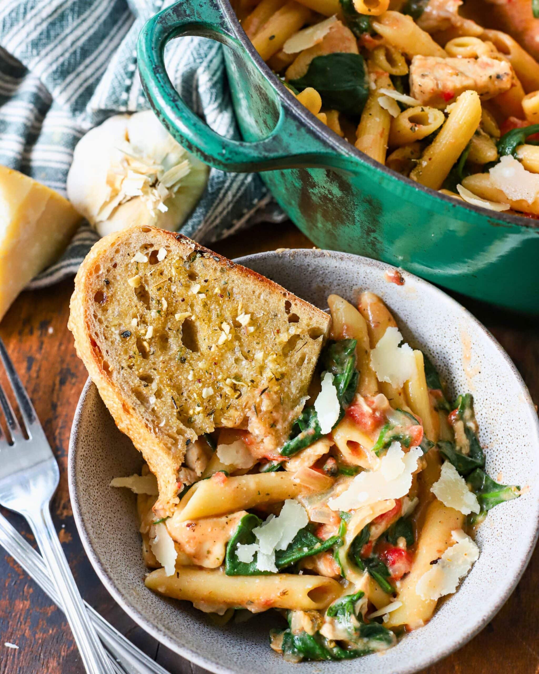 Bowl filled with chicken, tomato and spinach pasta.