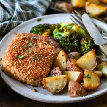 Plate with a pork chop and roasted potatoes.