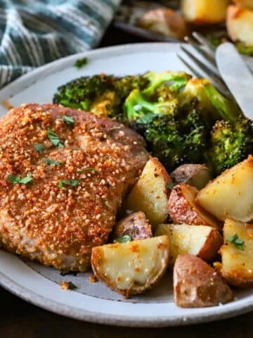 Plate with a pork chop and roasted potatoes.